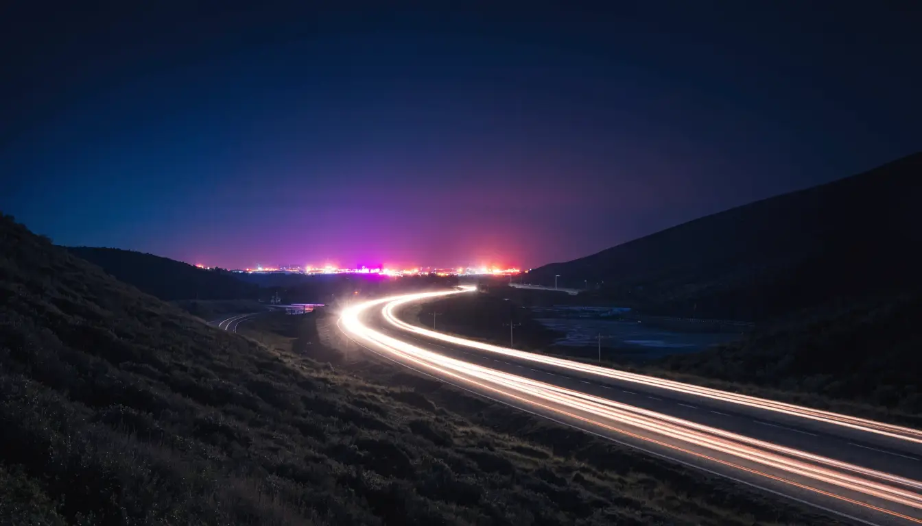 The SR-76 winding through dark valley hills toward casino glow — Oceanside's late-night corridor
